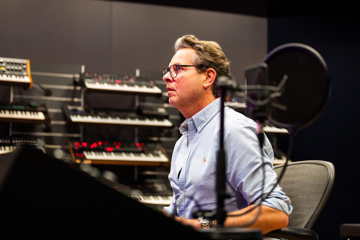 Christian Geller im Tonstudio vor der Synthesizer-Wand